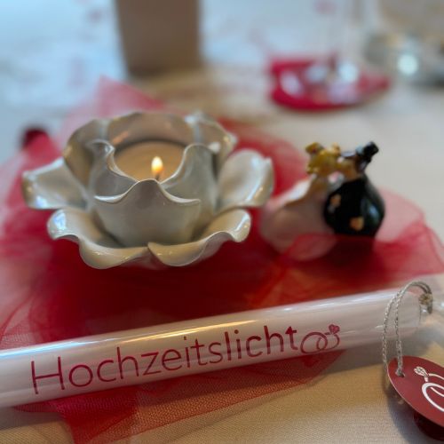 Kerze mit dem Spruch Hochzeitslicht am gedeckten Tisch